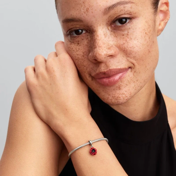 Röd blomma hängberlock i sterlingsilver från Pandora med kronbladseffekt i rött emalj och svarta kristaller. Symbol för din resa och utveckling.