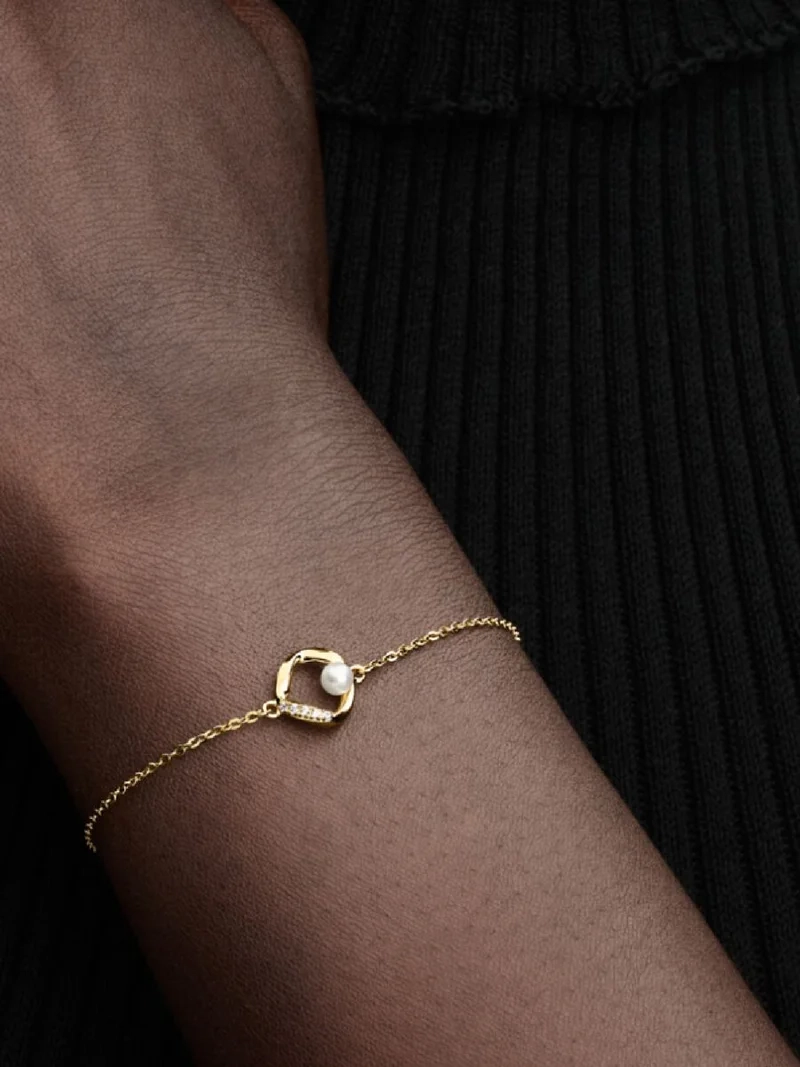 Armband med Organiskt Formad Sötvattenpärla Guld - Pandora Essence kollektion. Smyckad med gnistrande stenar och unikt behandlade pärlor för en subtil känsla av lyx.