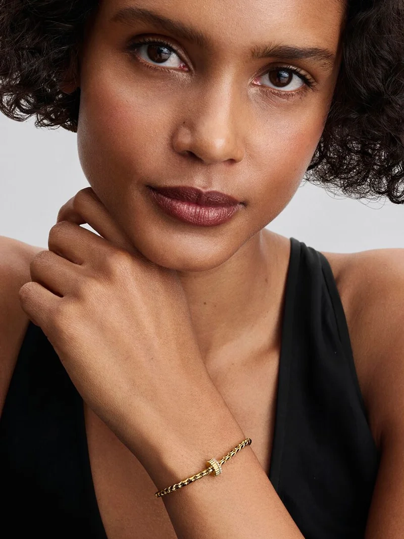 Elegant clipberlock i guld med kubisk zirkonia-stenar för en sofistikerad och säker look från Pandora Moments.