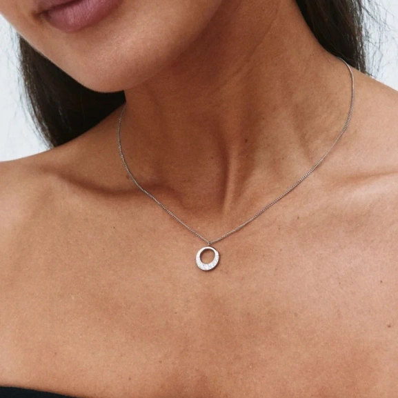 Halsband i polerat stål med runt hänge dekorerat med skimrande cubic zirconia-stenar från Edblads Monarch-kollektion.