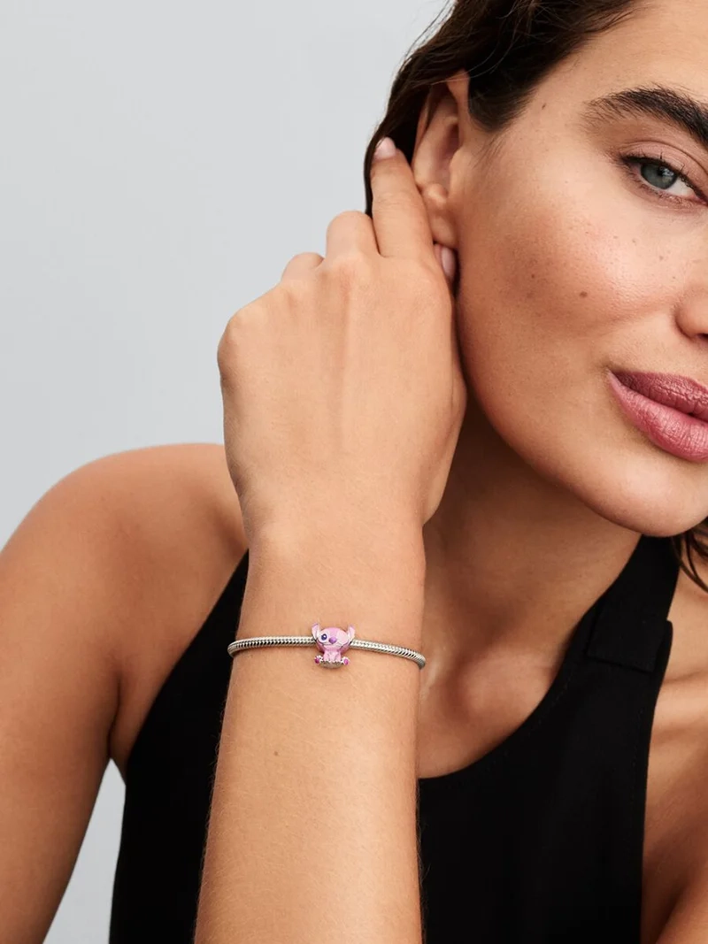 Disney Lilo & Stitch änglaberlock från Pandora i glänsande sterlingsilver med lila och rosa emalj. En lekfullt elegant tillskott till din smyckessamling