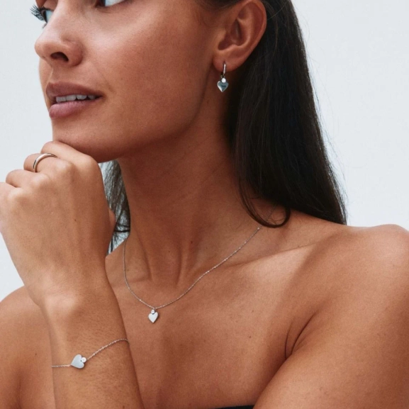 Armband i blankt rostfritt stål med stiliserat hjärta och gnistrande sten på fasettslipad ankarkedja.