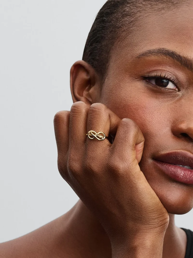 Förgylld ring med evighetsknut och gnistrande stenar från Pandora Moments kollektionen. En symbol för evig kärlek och harmoni