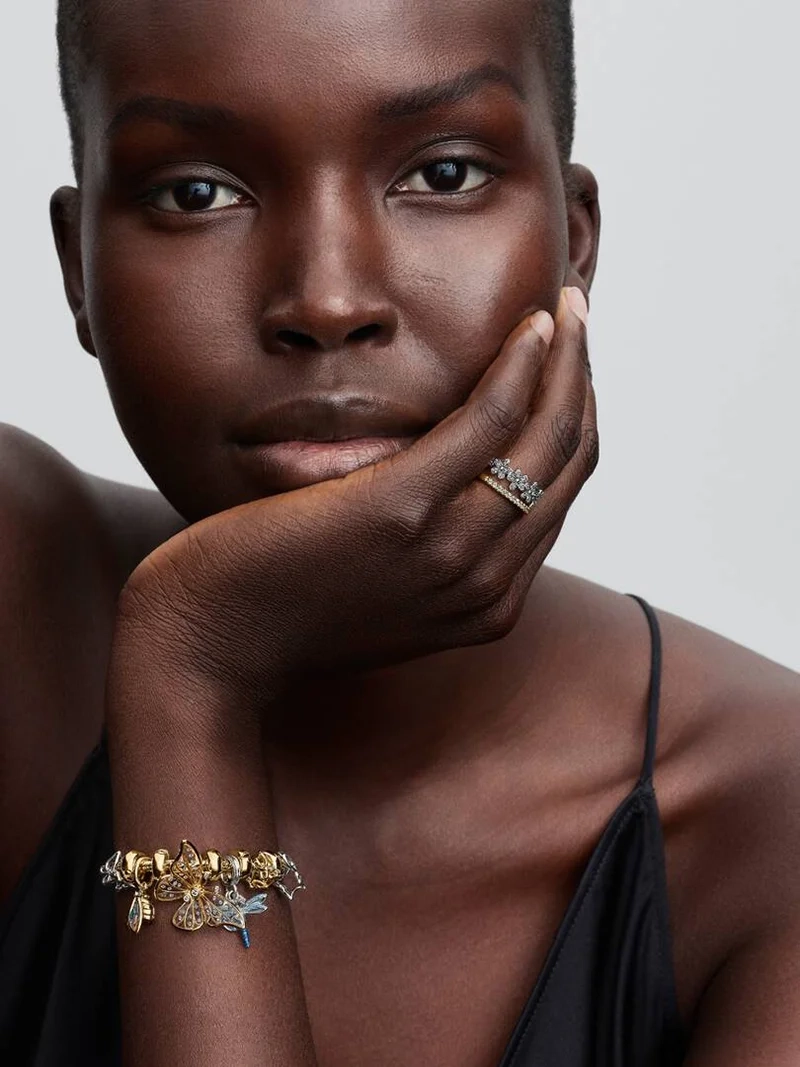 guldpläterad med skimrande stenar och öppen fjärilsdesign.