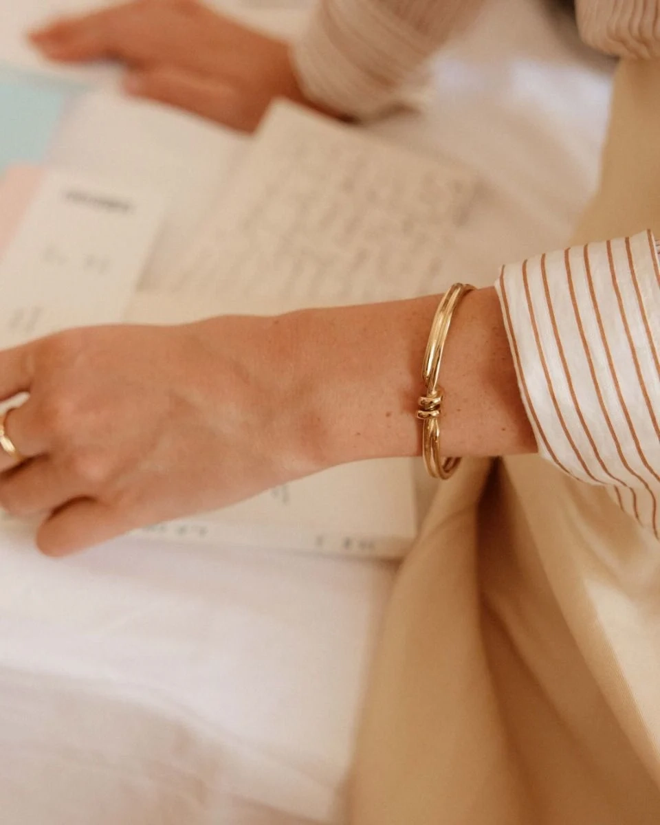 Guldpläterad bangle med spiralform och oval pärlemorpärla från Edblads Swivel-kollektion