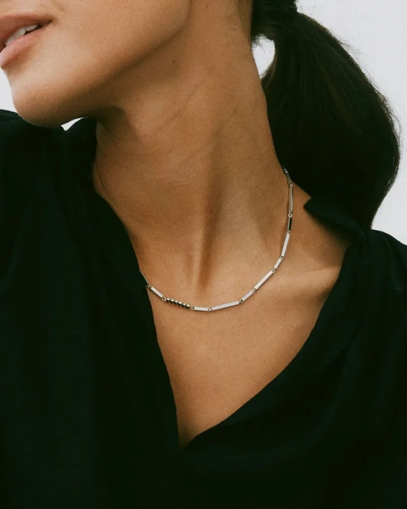 Elegant halsband i polerat stål med arkitektoniska stavar och sex gnistrande cubic zirconia-stenar