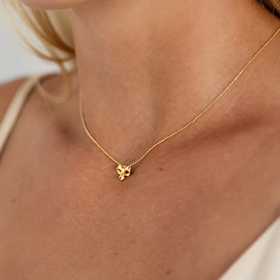 ett elegant halsband i 18K guldpläterat silver med rosettberlock och gnistrande kedja.