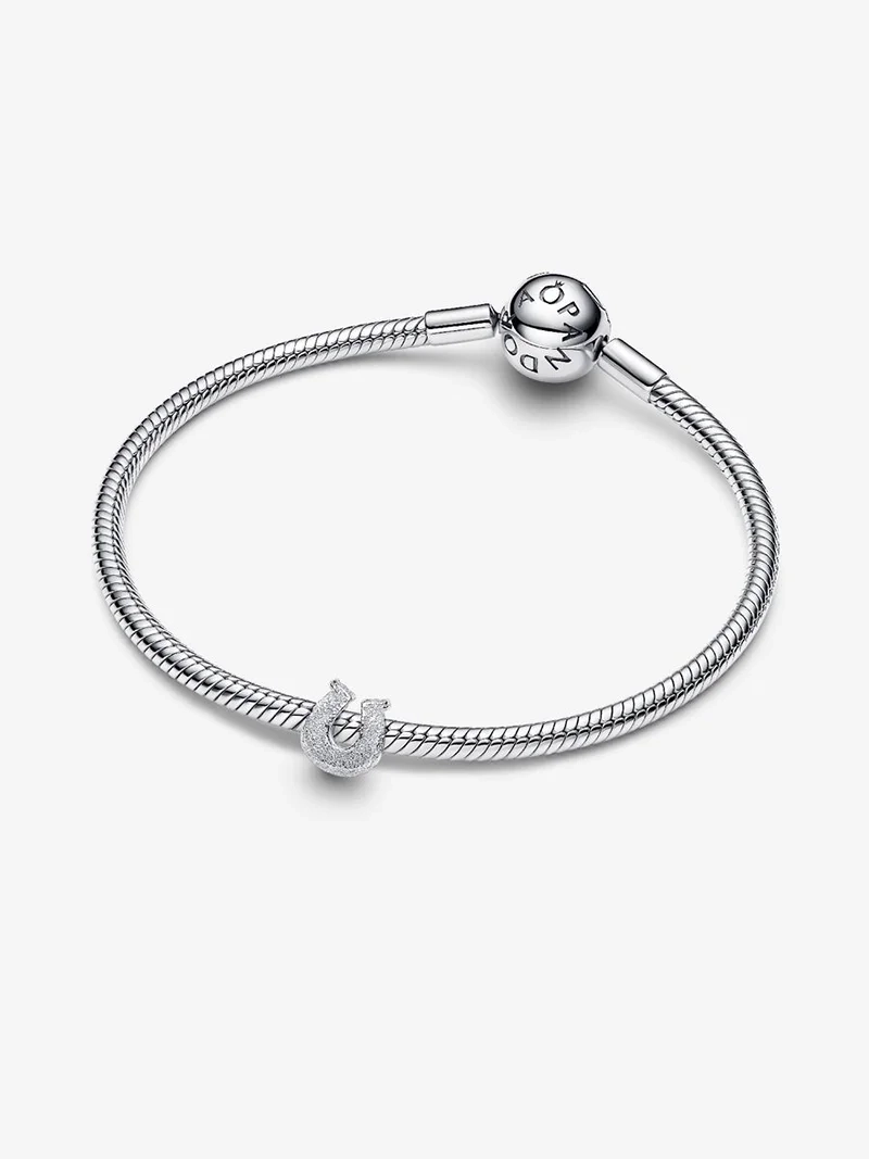 Hästskoberlock i glittrande silver från Pandora Moments. Skapa lycka och elegans med denna charm som liknar skimrande diamanter. Lägg till en touch av lyx i din stil och sprid glädje varje dag.