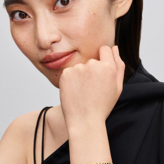 tillverkad av 14 karat guldplätering och skimrande diamanter. Låt den påminna dig om din oändliga styrka och glans.