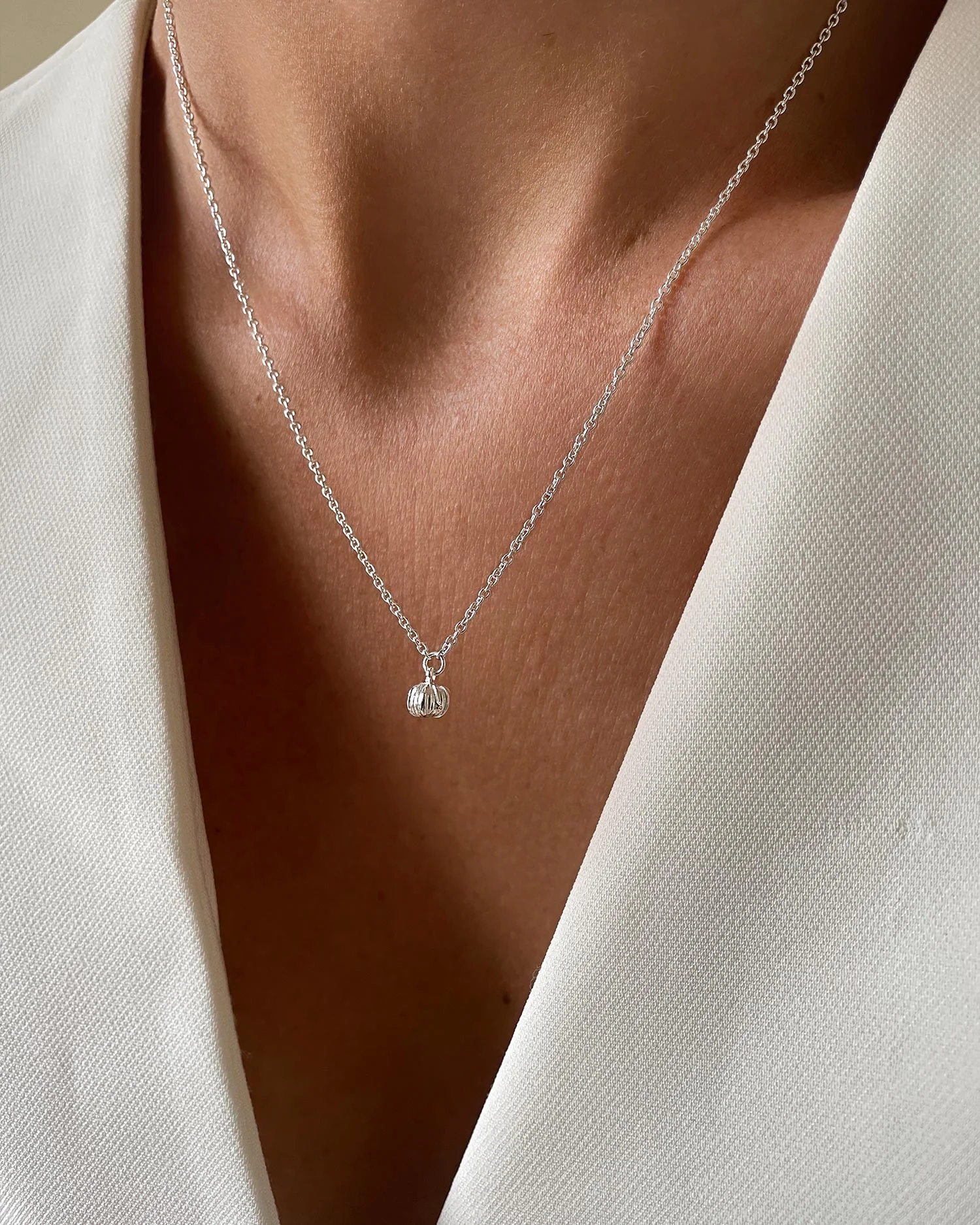 kort silverhalsband med blomknoppshänge