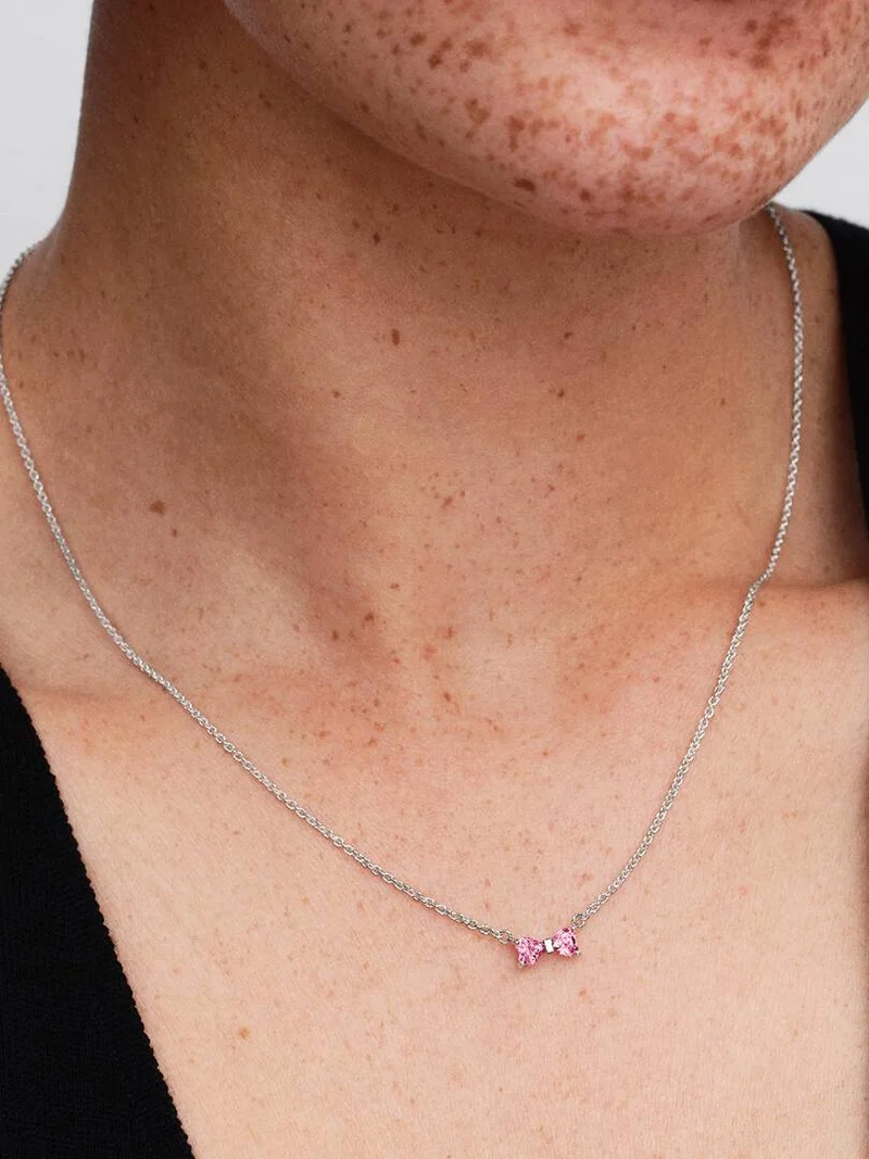 Rosa halsband med hjärtformade stenar i rosett av sterlingsilver från Pandora Timeless kollektionen. Justerbar längd för personlig stilanpassning.