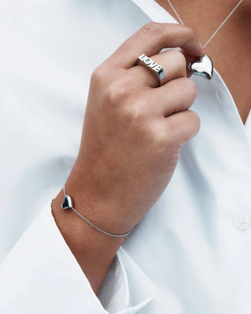 Armband i blankt rostfritt stål med hjärtformat smycke centrerat på kedjan