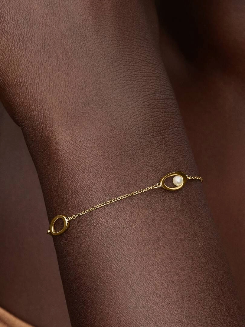 pläterat med 14K guld och dekorerat med vit sötvattenpärla och ovala detaljer.