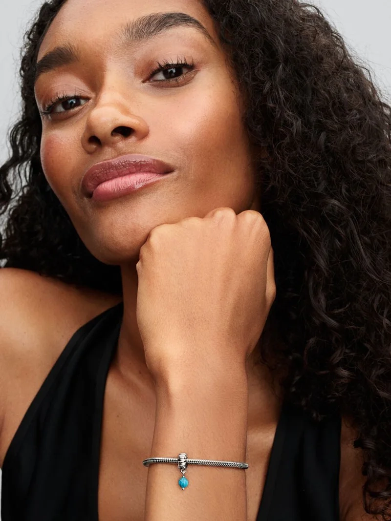 Turkosfärgad hängberlock från Pandora Moments i sterlingsilver. Unik struktur med rund turkosfärgad berlock. Lekfull uppfräschning av din stil.