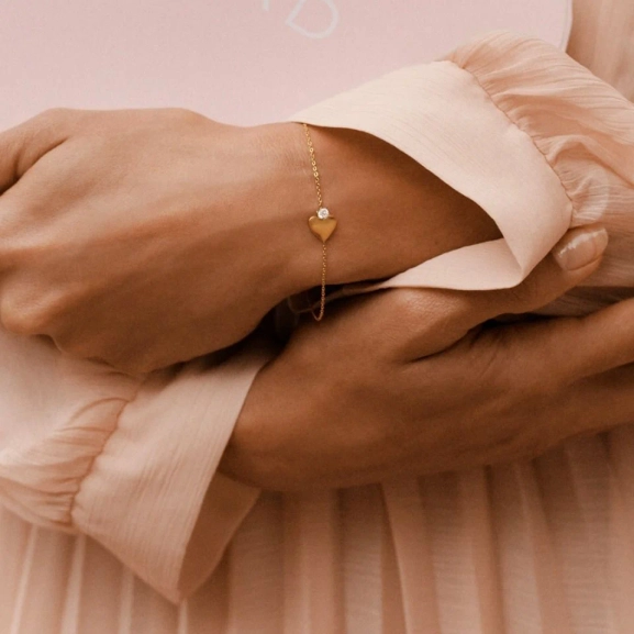 Armband i 14K guldplätering med fasettslipad kedja och stilrent hjärta prytt av en liten gnistrande sten.