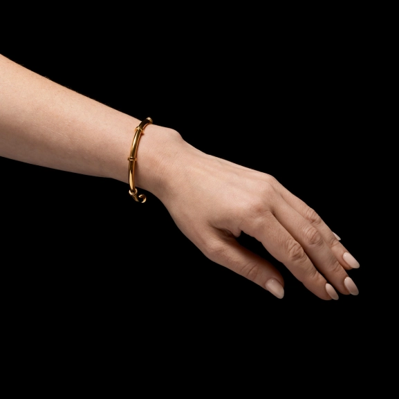 skulpturales Armband aus 18-karätig vergoldetem Silber mit offenem Band und ringförmigen Bolzendetails.