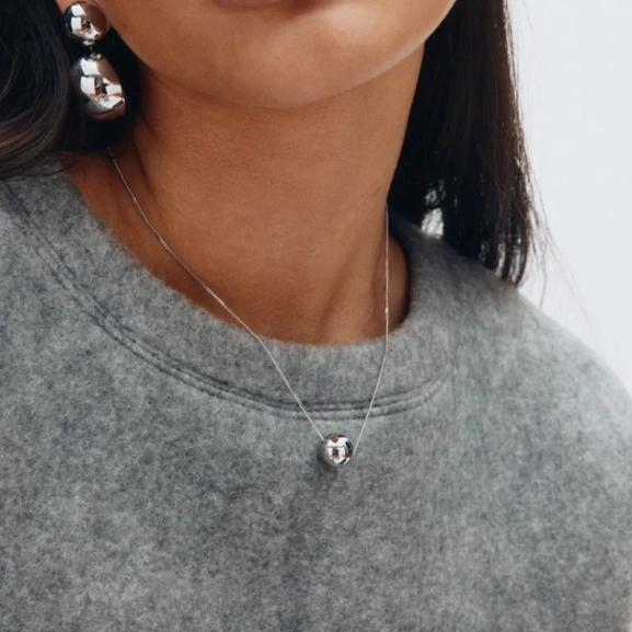 med en elegant rund hängsmycke-design