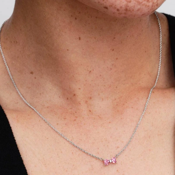 Rosa halsband med hjärtformade stenar i rosett av sterlingsilver från Pandora Timeless kollektionen. Justerbar längd för personlig stilanpassning.