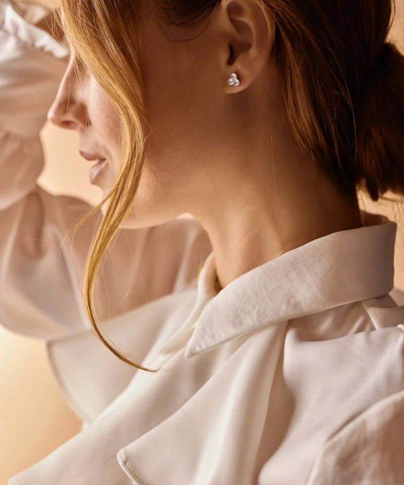 Klöverformade örhängen med gnistrande kristaller i medicinsk titan