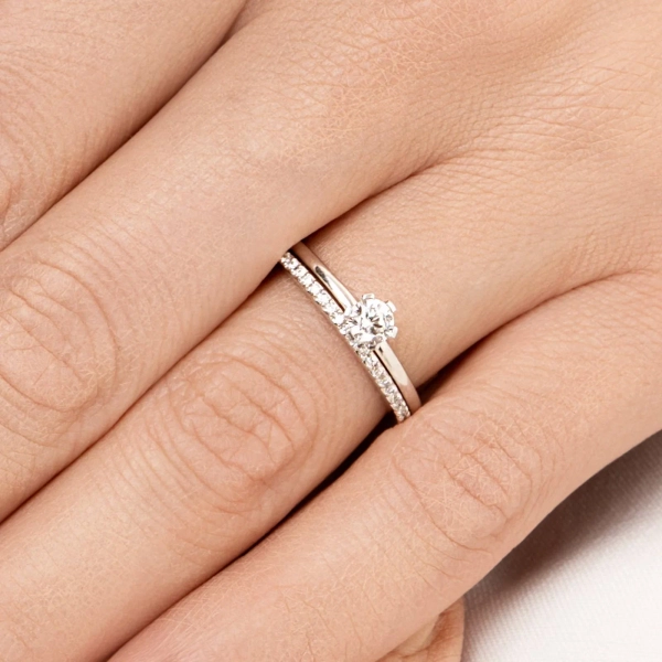 High On Love & Stars Ring i 18K vitguld med en större briljantslipad diamant och mindre pavédiamanter längs den smala skenan
