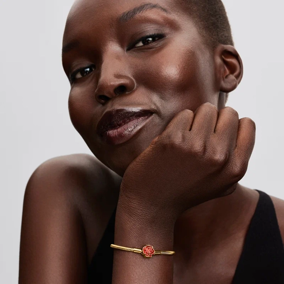 inspirerat av Disneys Skönheten och odjuret. Tillverkat av 14 karat guldplätering med rosformat lås i emalj.