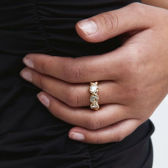 Ring i 14K guldplätering med gnistrande stenar runt hela bandet och mjukt polerad insida