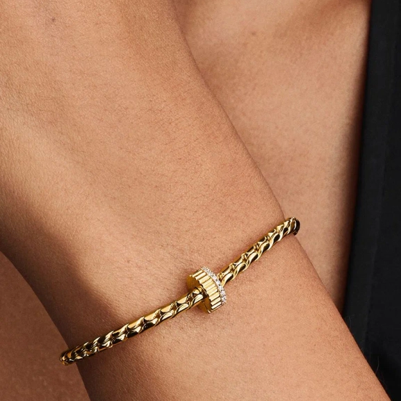 Elegant clipberlock i guld med kubisk zirkonia-stenar för en sofistikerad och säker look från Pandora Moments.