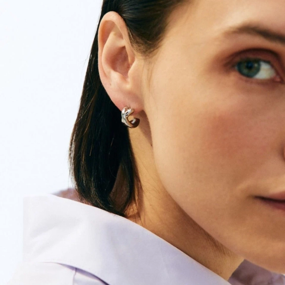 blanka hoops i polerat rostfritt stål med stilren design som omsluter örsnibben för en modern och elegant look.