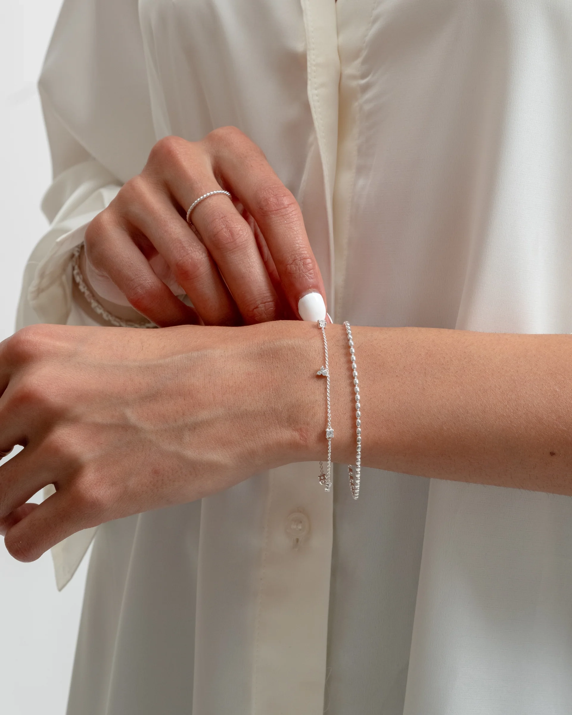 tunt armband i återvunnet silver med gnistrande kubiska zirkoner i olika former.