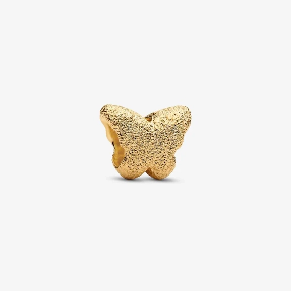 Fjärilsberlock i guld med diamantliknande struktur från Pandora Minis kollektion. Liten men betydelsefull