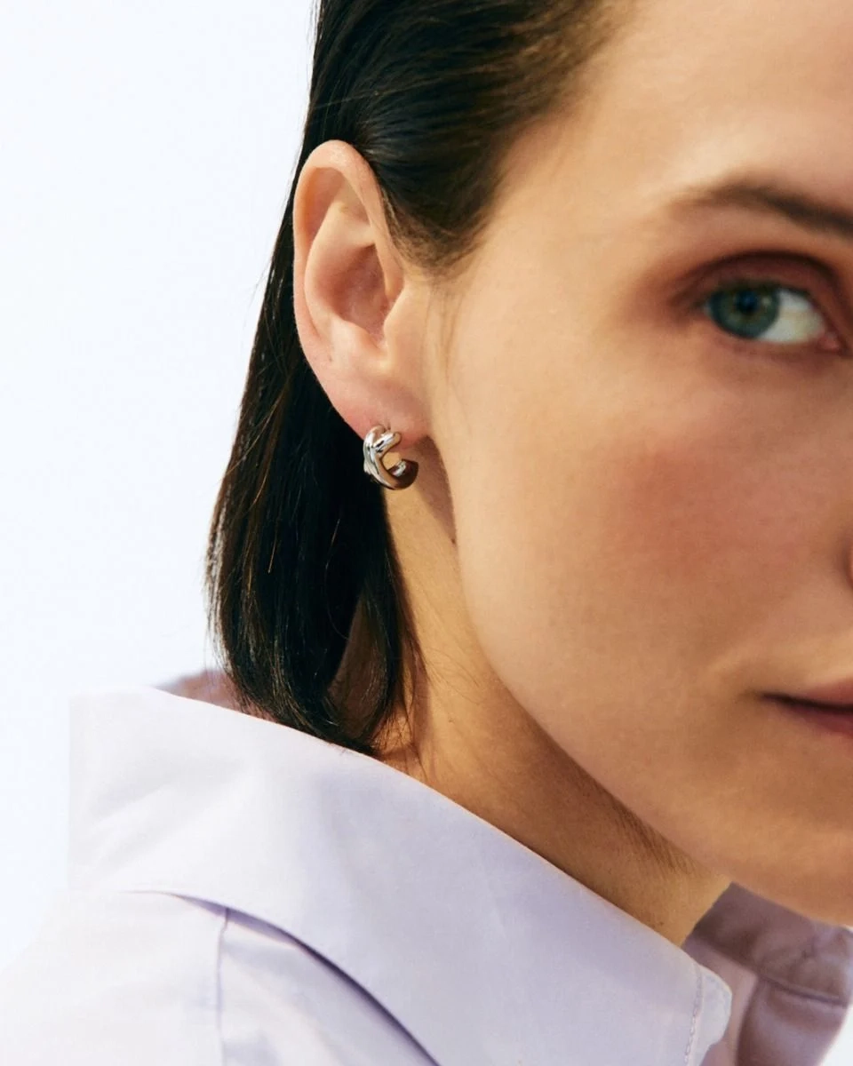 blanka hoops i polerat rostfritt stål med stilren design som omsluter örsnibben för en modern och elegant look.