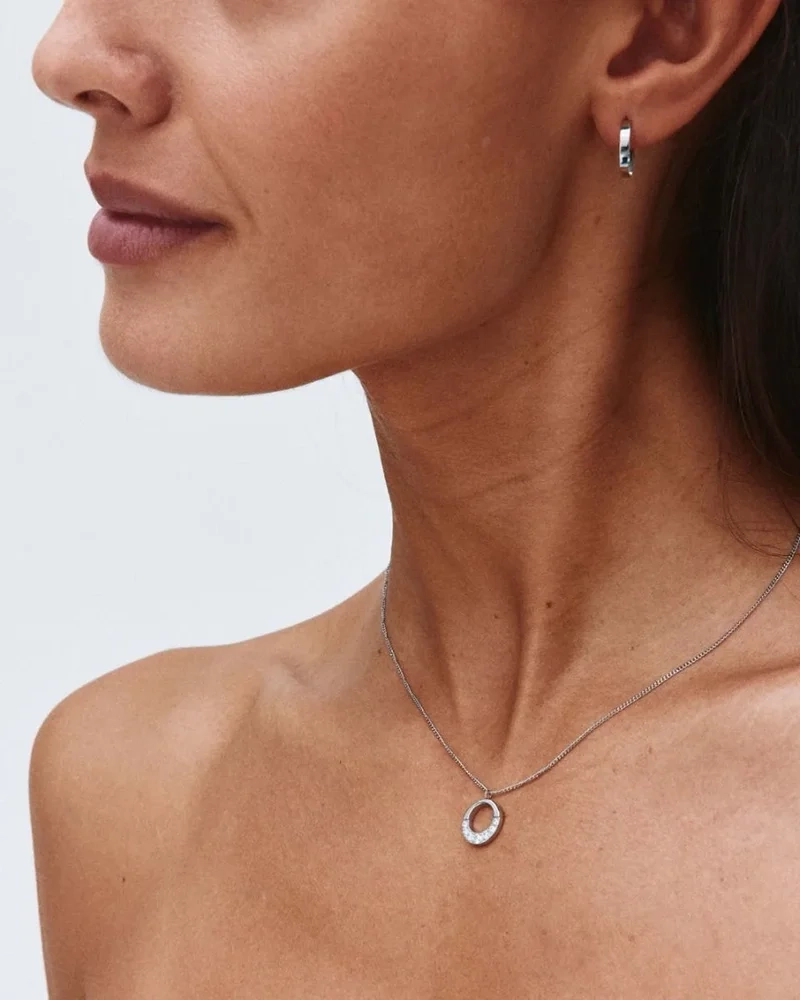 Halsband i polerat stål med runt hänge dekorerat med skimrande cubic zirconia-stenar från Edblads Monarch-kollektion.