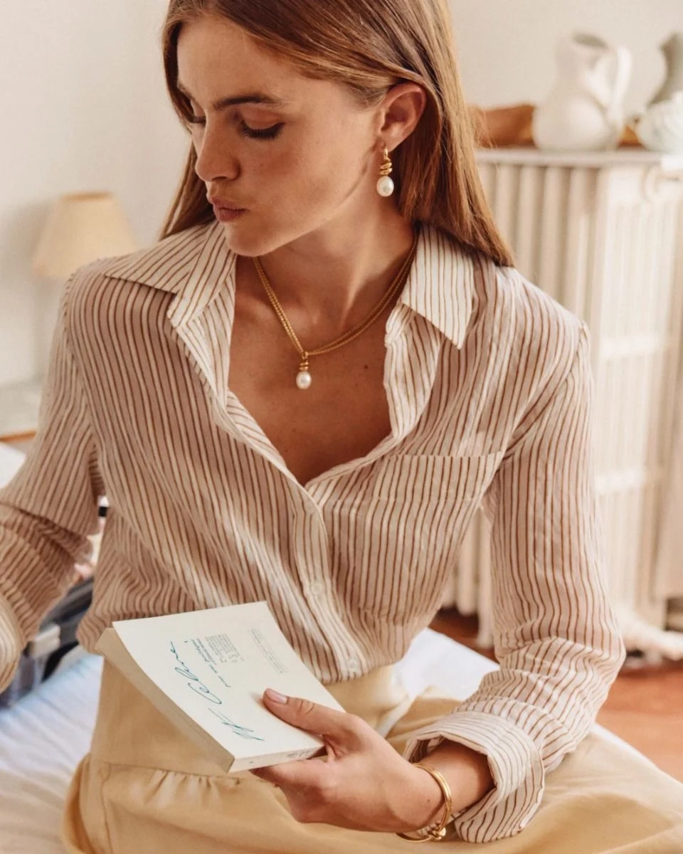 Större studsörhängen i 14K guldplätering med spiralform och oval pärlemorpärla från Edblad Swivel-kollektionen.