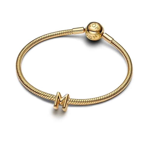 Bokstaven M Berlock Guld från Pandora Moments: Ge din stil extra glamour med denna eleganta bokstavsberlock i 14K guldpläterad metall. Skapa ditt unika budskap med denna sofistikerade design.