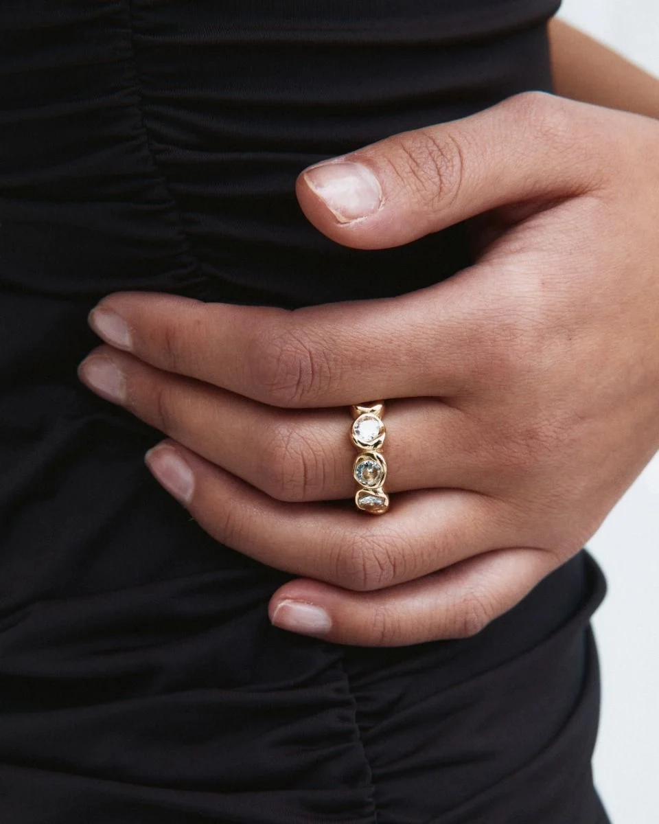 Ring i 14K guldplätering med gnistrande stenar runt hela bandet och mjukt polerad insida