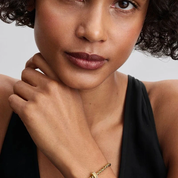 Elegant clipberlock i guld med kubisk zirkonia-stenar för en sofistikerad och säker look från Pandora Moments.