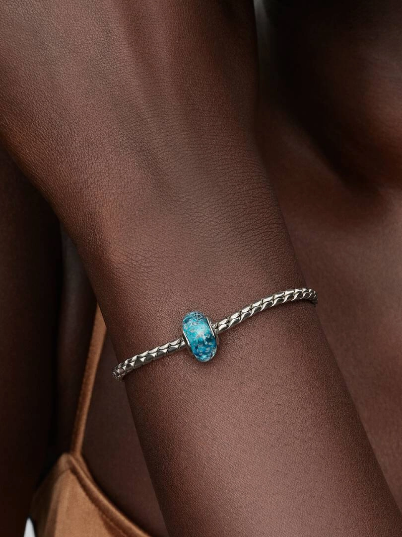 Turkosfärgad Murano Berlock från Pandora i silver med blått skimrande muranoglas och strukturerad yta.