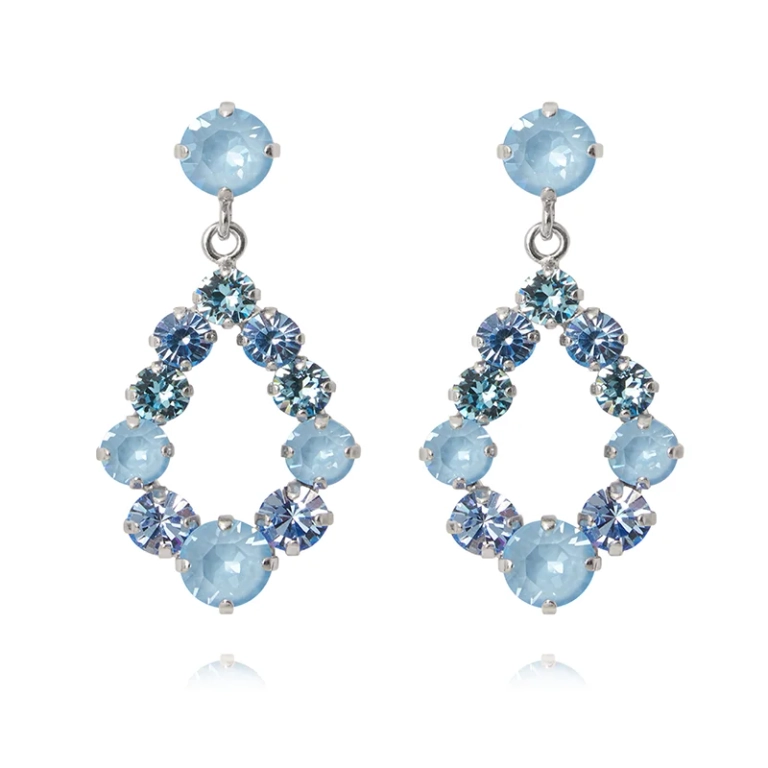Droppformade örhängen med ljusblå Swarovski-kristaller i rhodiumpläterad mässing från Caroline Svedbom.