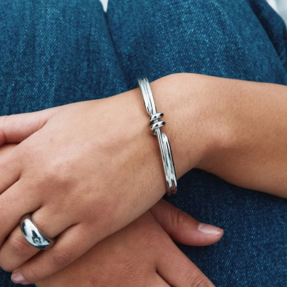 Armband i blankt rostfritt stål med spiralformad detalj och oval pärlemorpärla