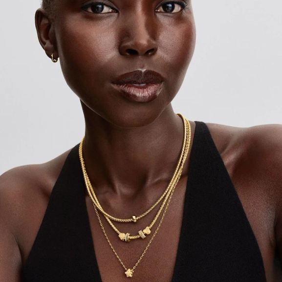 Elegant clipberlock i guld med kubisk zirkonia-stenar för en sofistikerad och säker look från Pandora Moments.