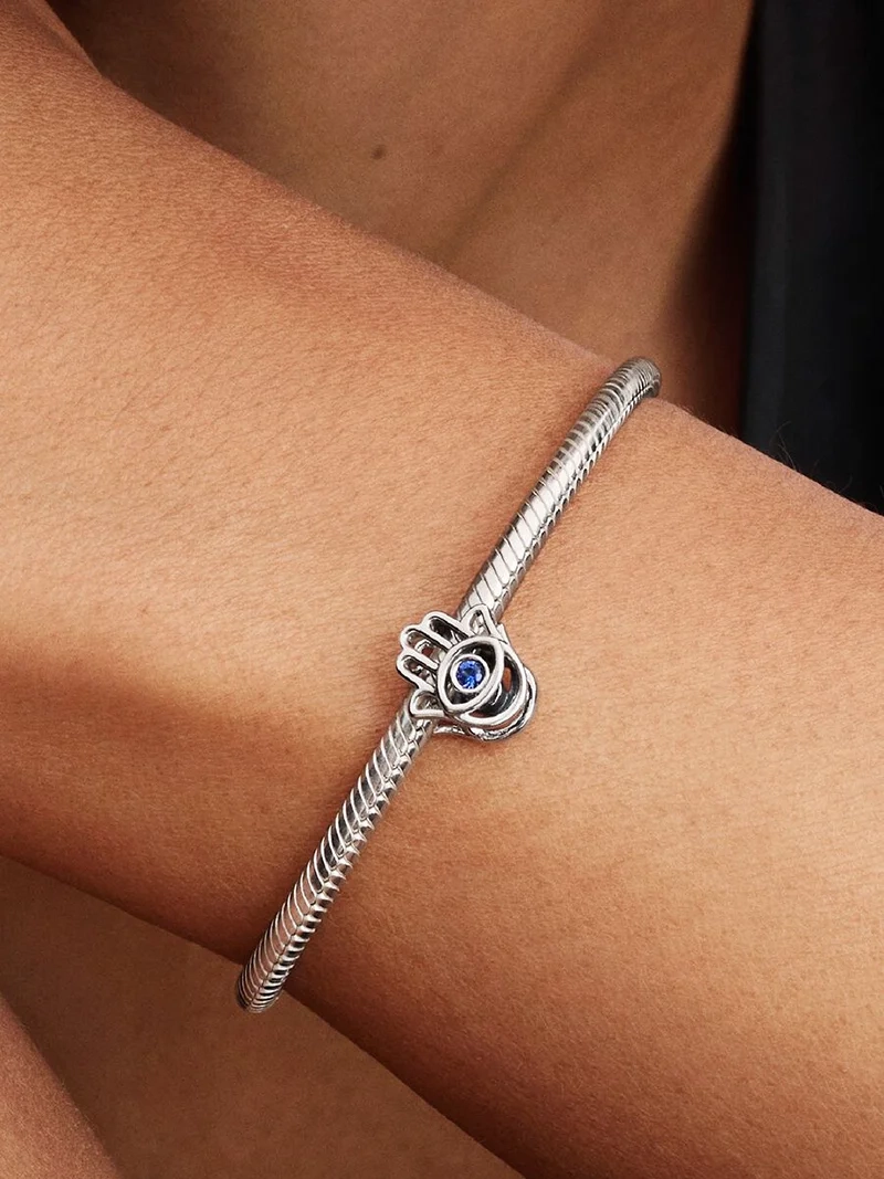 Hamsa-berlock från Pandora med blåa kristaller för styrka och lugn. Symbol för positiv energi och skydd