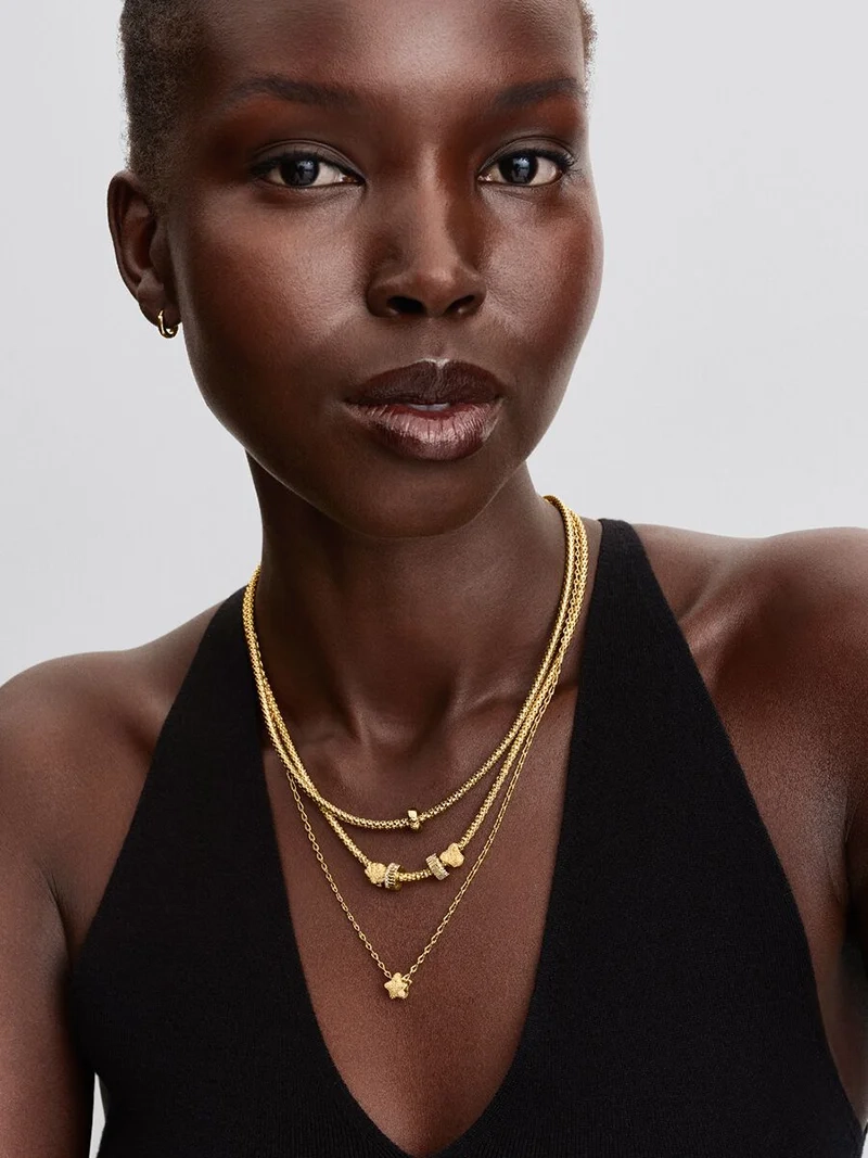 Elegant clipberlock i guld med kubisk zirkonia-stenar för en sofistikerad och säker look från Pandora Moments.