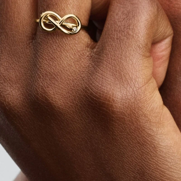 Förgylld ring med evighetsknut och gnistrande stenar från Pandora Moments kollektionen. En symbol för evig kärlek och harmoni