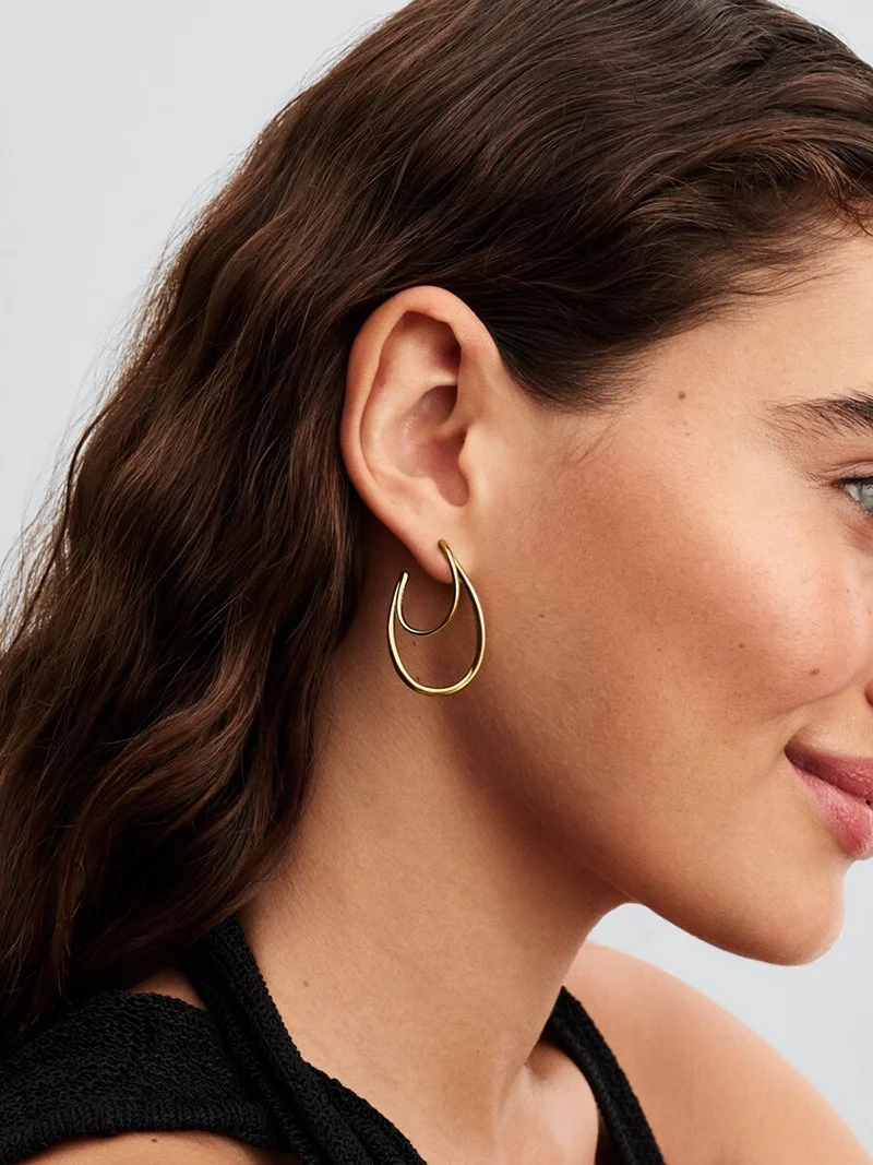 Eleganta dubbla hoops i 14 karat guldpläterad metall med organiskt formade ovaler och charmiga fjärilslås från Pandora Essence kollektionen.