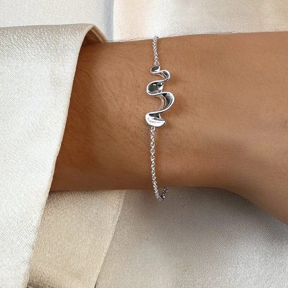 skulpturalt och tidlöst armband inspirerat av vattenflöde.