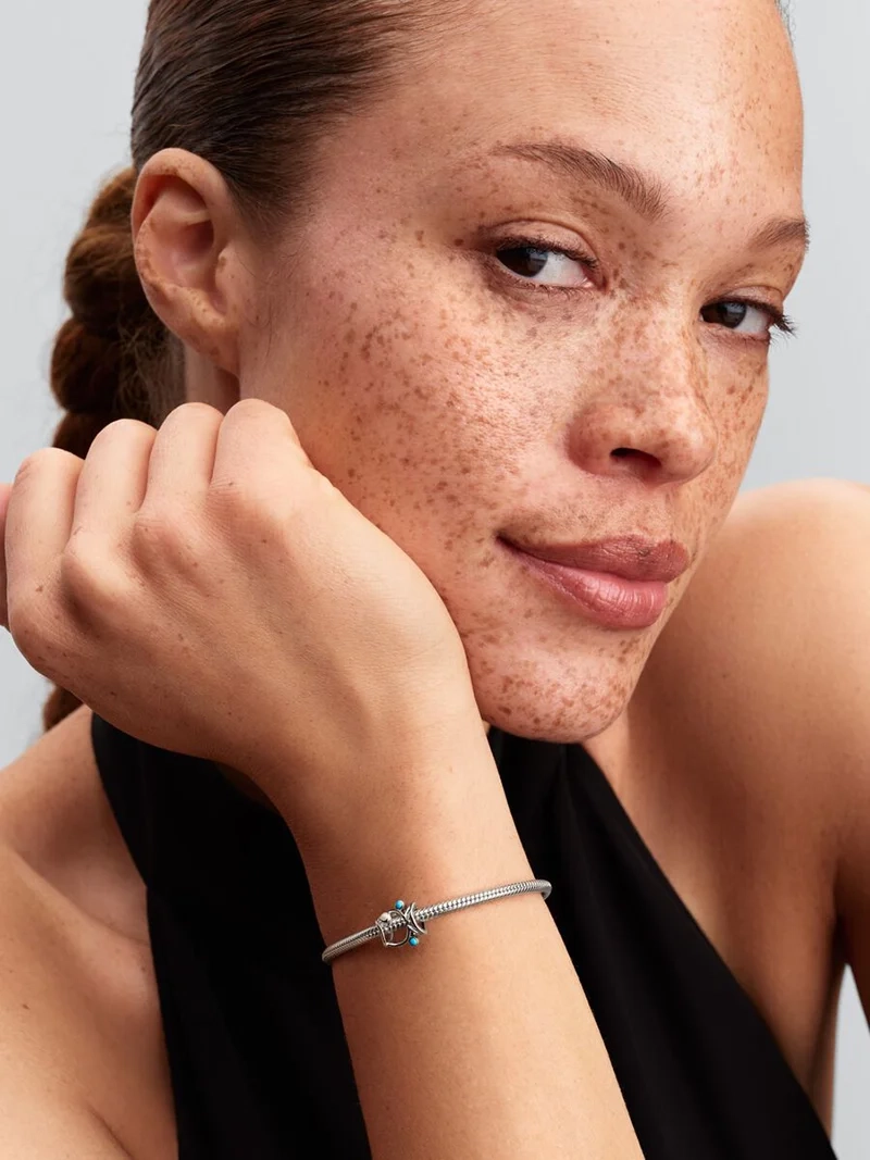 Berlock i sterlingsilver från Pandora med skimrande emalj i vit och turkos färg. Symbol för överflöd och skydd