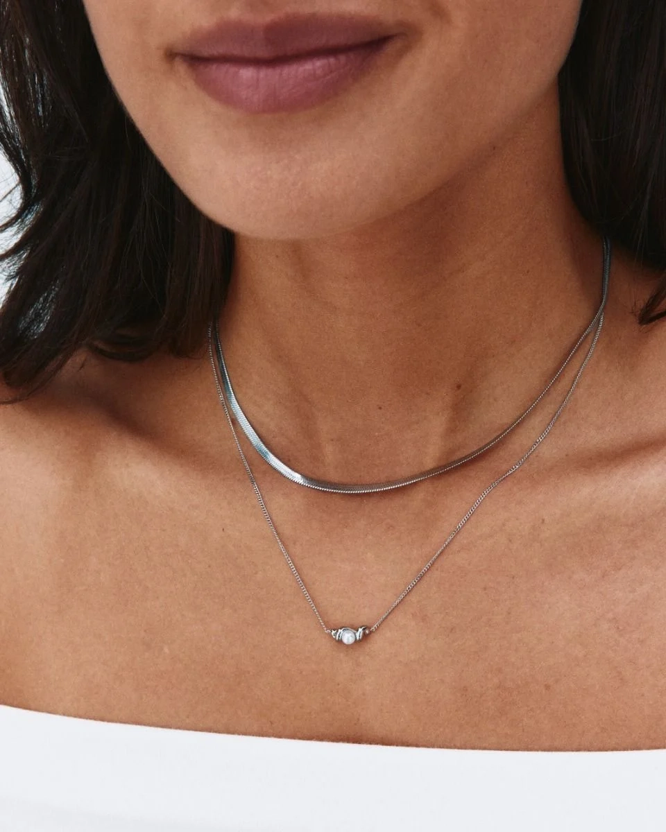 Halsband i polerat stål med tvinnad design och pärlemorpärla på klassisk pansarkedja från Edblad