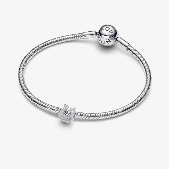 Hästskoberlock i glittrande silver från Pandora Moments. Skapa lycka och elegans med denna charm som liknar skimrande diamanter. Lägg till en touch av lyx i din stil och sprid glädje varje dag.