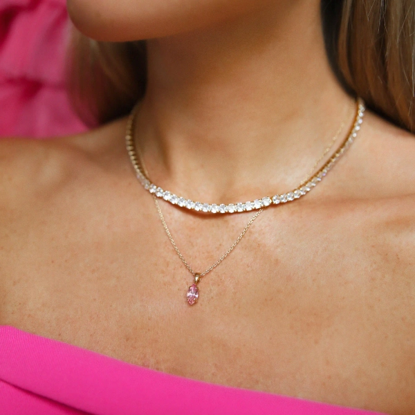Petite Navette Necklace i guld med ljusrosa kristaller. Elegant och tidlös design för alla tillfällen.