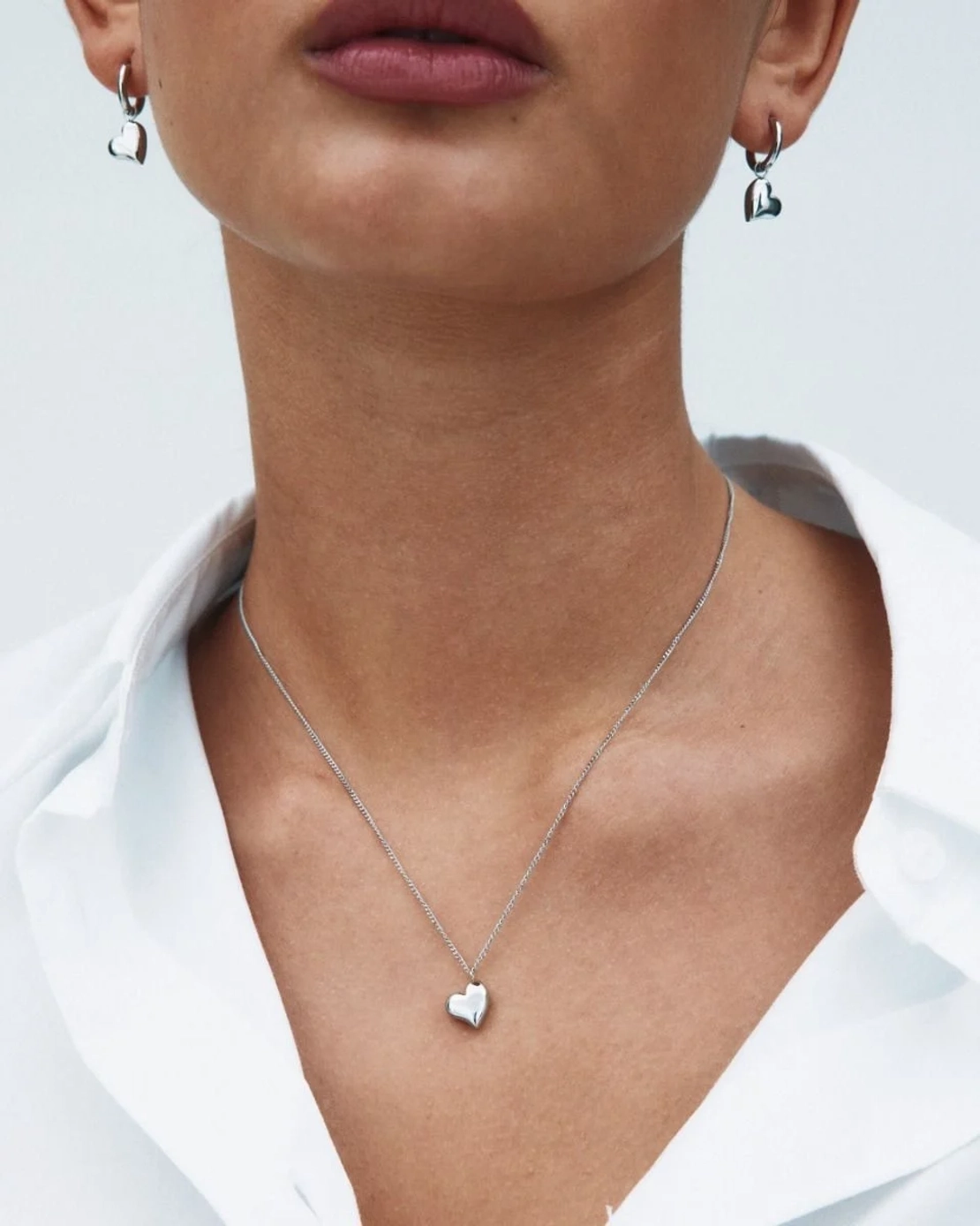 Halsband och örhängen i blankt stål med hjärtformad design